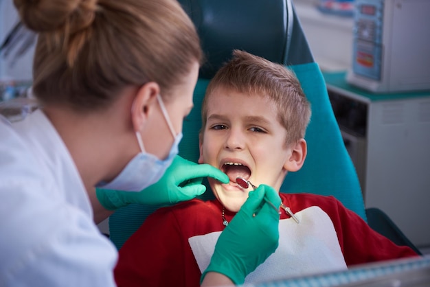 Garoto em um chech de dentes de cirurgia dentária