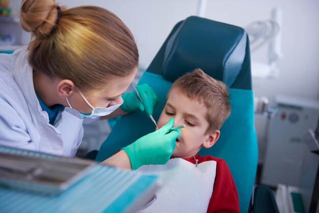 Garoto em um chech de dentes de cirurgia dentária