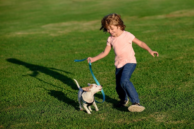 Garoto engraçado com cachorrinho Adolescente no parque brinca com um cãozinho de estimação de amizade