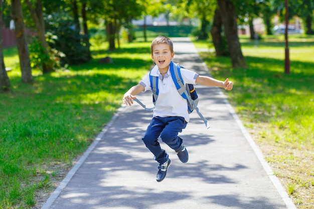 garoto engraçado feliz da escola voltando para a escola garoto fofo com mochila correndo