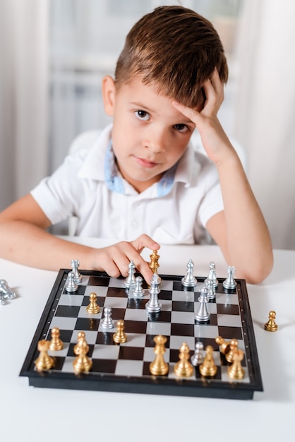 Menino Ruivo Nos óculos Sentado Em Casa E Jogando Xadrez Sozinho