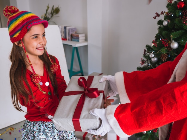 Foto garoto feliz em receber presentes do papai noel