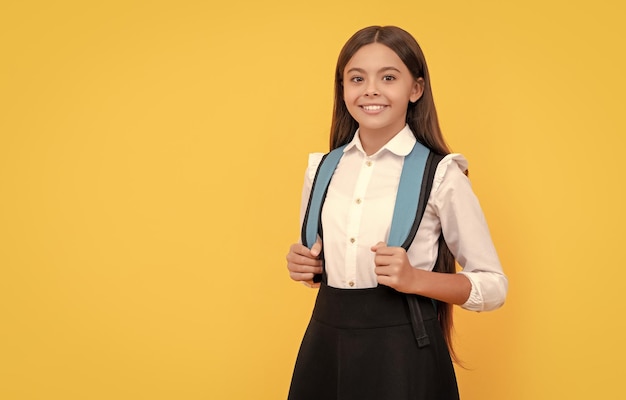 Garoto feliz em uniforme escolar carrega espaço de cópia de mochila de volta à escola