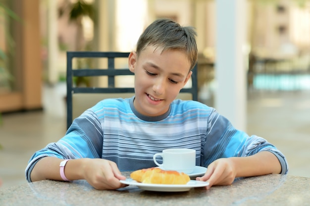 Foto garoto feliz no café da manhã na mesa