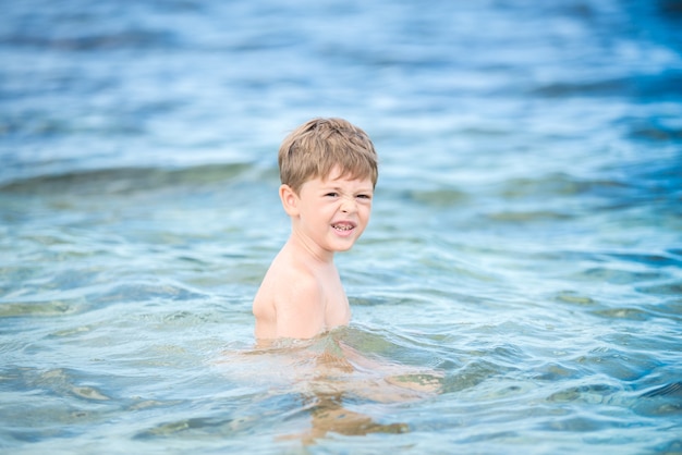 Garoto feliz no mar no verão.