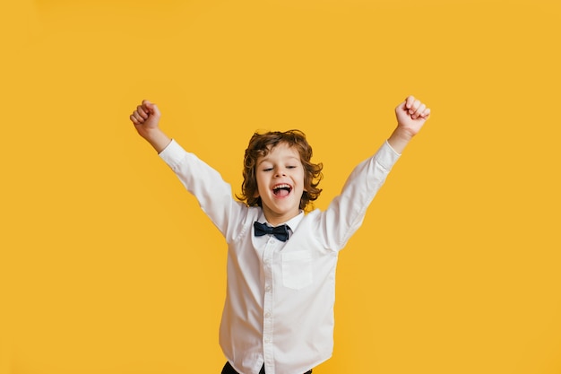 Garoto feliz ri engraçado, grita de surpresa, levantando as mãos,