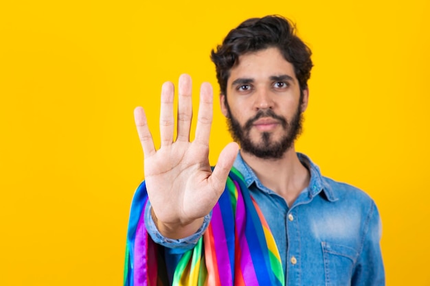 Garoto homossexual do orgulho gay com a mão para a frente fazendo um sinal de pare ao preconceito