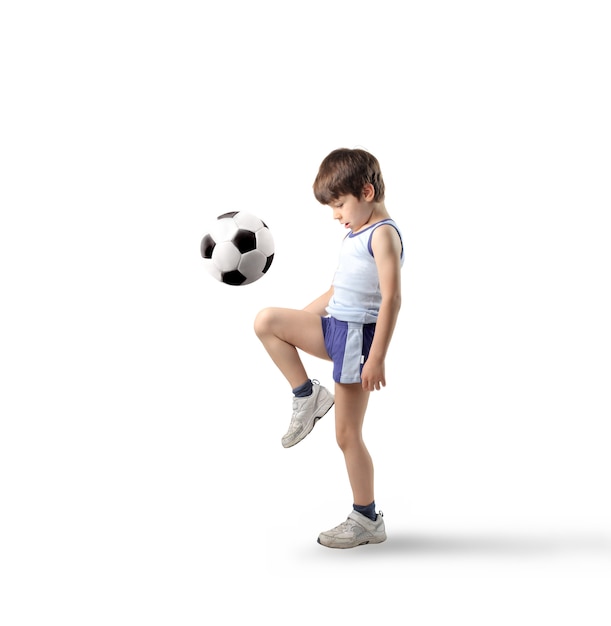 Garoto jogando com bola de futebol