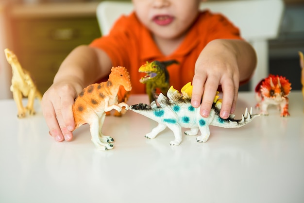 Garoto jogando com dinossauros. Coleção lagarto