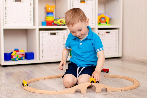 Garoto jogando com um trem de madeira