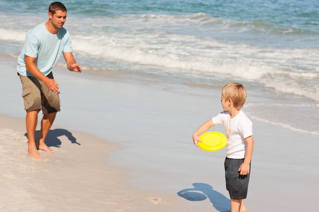 Garoto jogando frisbee com seu pai