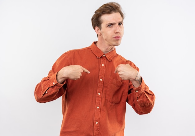Garoto jovem e confiante com uma camisa vermelha apontando para si mesmo