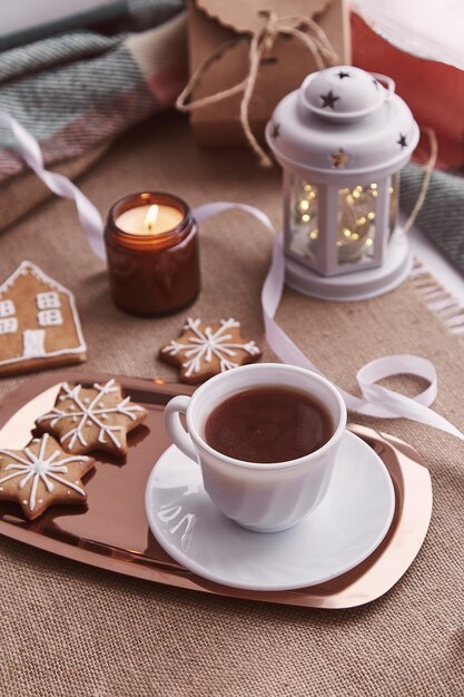 Garoto leva biscoitos de gengibre de Natal Decorações de Natal festivas atmosféricas com chocolate quente Conceito de aconchego e calor em casa
