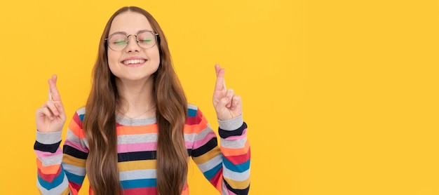 Garoto nerd de estudante sonhadora sorridente em óculos para visão cruzou os dedos fazendo sonho de desejo criança rosto cartaz horizontal adolescente menina isolado retrato banner com espaço de cópia