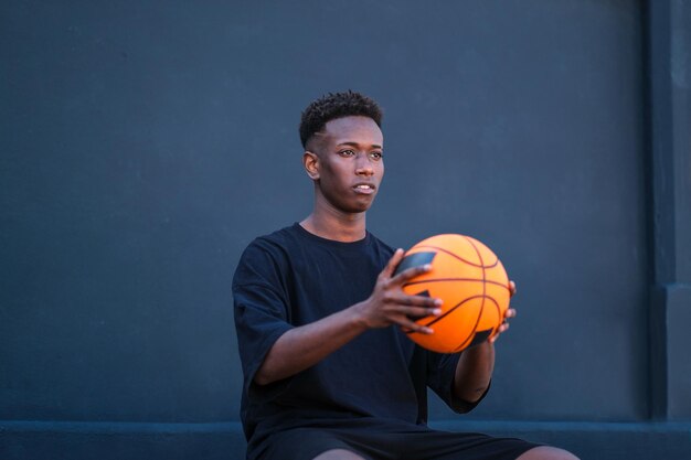 Garoto segurando basquete com fundo preto