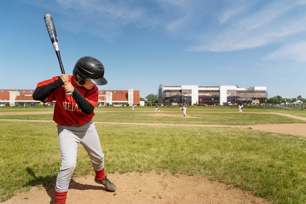 Foto garoto segurando o taco de beisebol tiro completo