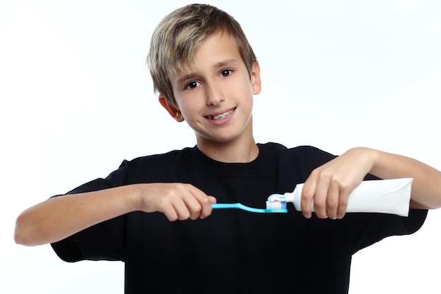 Garoto segurando uma escova de dentes e se preparando para escovar os dentes enquanto olha para você