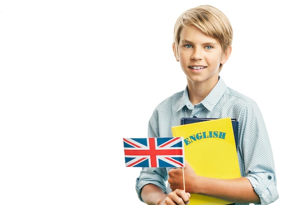 Garoto sorridente segurando a bandeira britânica e livros em inglês