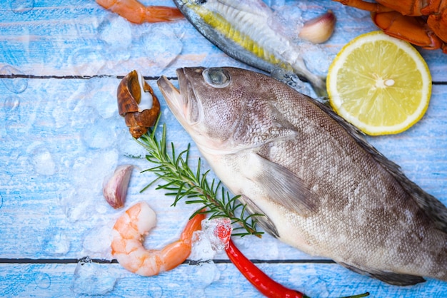 Garoupa no gelo com alecrim e limão, frutos do mar crus frescos para alimentos cozidos