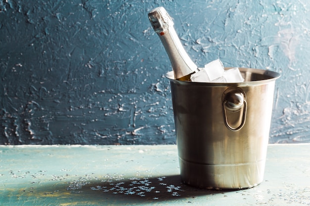 Garrafa de champanhe no balde com gelo e taças de champanhe