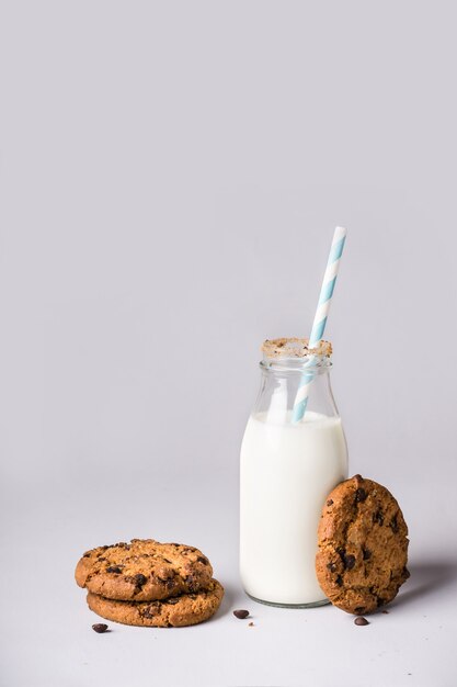 Garrafa de leite é decorada com migalhas de biscoitos e biscoitos de chocolate.