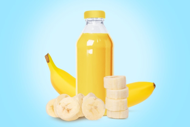 Garrafa de néctar de suco de banana fresco Um conjunto de bananas inteiras e pedaços Sobre um fundo azul