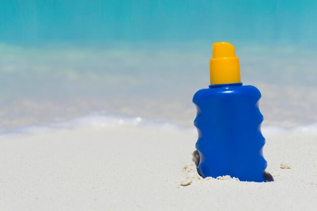 Garrafa de proteção solar loção solar em uma praia tropical