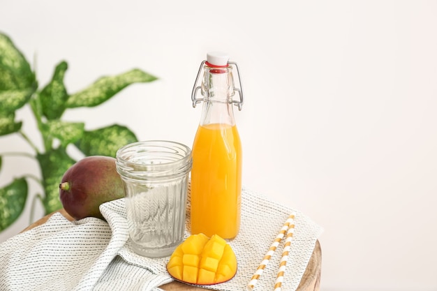 Garrafa de saboroso suco de manga e copo na mesa