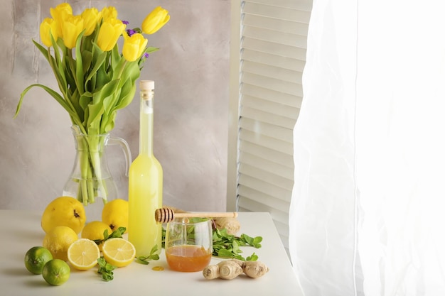 Garrafa de suco caseiro com gengibre e limão na luz de fundo horizontal