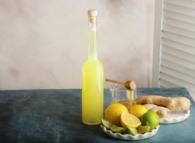 Garrafa de suco caseiro com gengibre e limão na luz de fundo horizontal