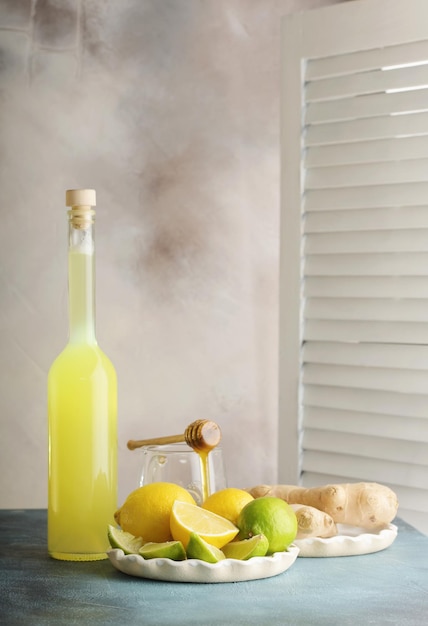 Garrafa de suco caseiro com gengibre e limão na luz de fundo Vertical