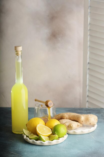 Garrafa de suco caseiro com gengibre e limão na luz de fundo Vertical