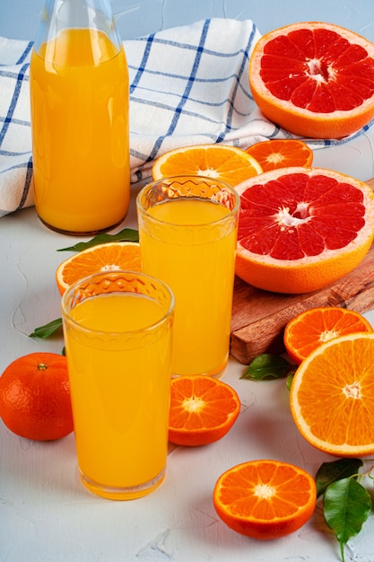 Garrafa de suco de laranja e laranjas frescas na mesa