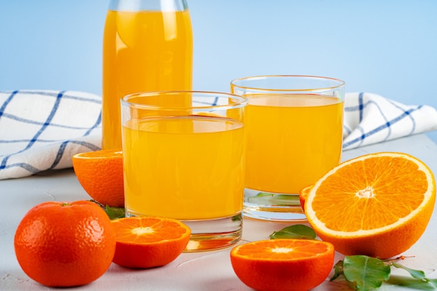 Garrafa de suco de laranja e laranjas frescas na mesa