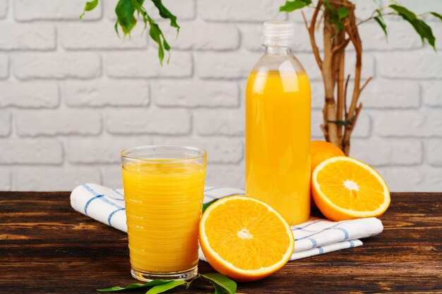 Garrafa de suco de laranja fresco na mesa de madeira