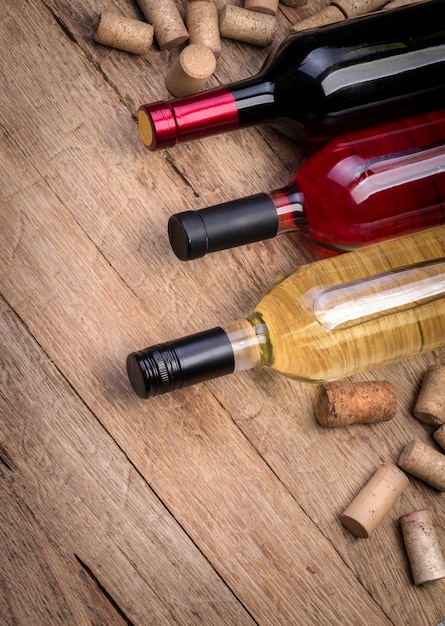 Garrafa de vidro de vinho com rolhas na mesa de madeira