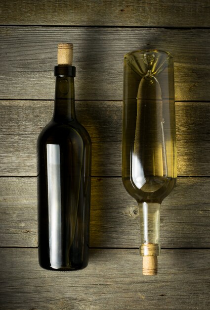 Garrafa de vidro de vinho com rolhas no fundo da mesa de madeira