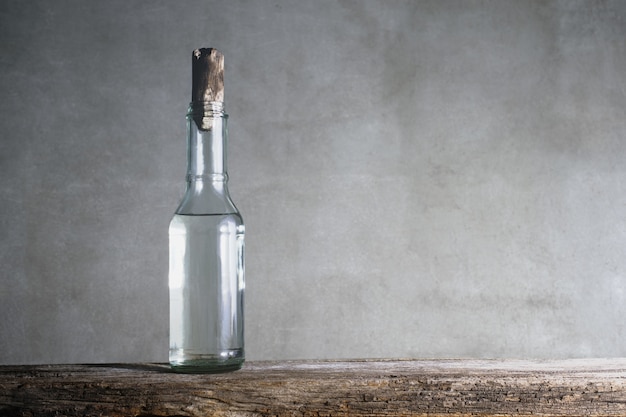 Garrafa de vinagre branco na mesa de madeira.