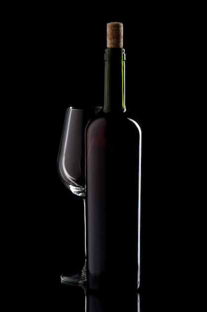 Garrafa de vinho com rolha e copo vazio em preto isolado