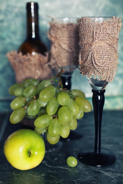 Garrafa de vinho de conjunto de férias com uva verde no fundo