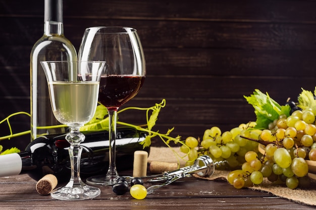 Garrafa de vinho e uva na mesa de madeira