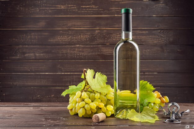 Garrafa de vinho e uva na mesa de madeira