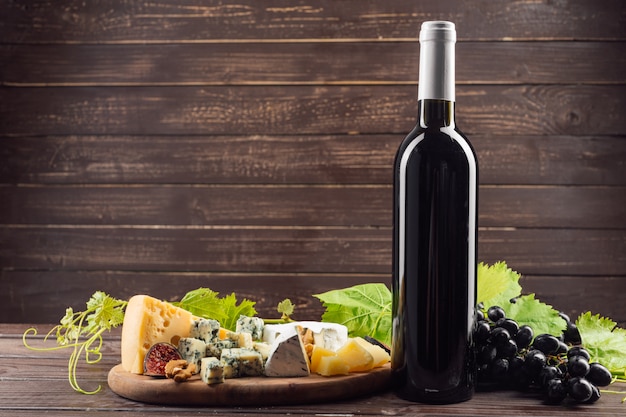 Garrafa de vinho e uva na mesa de madeira