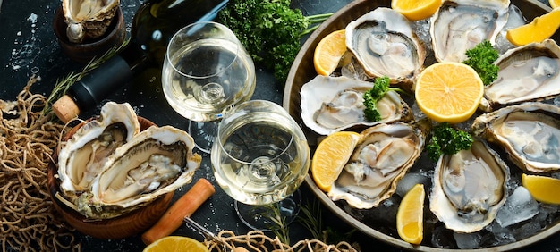 Garrafa de vinho envelhecido e ostras frescas em uma mesa de cozinha escura Frutos do mar Vista superior Postura plana