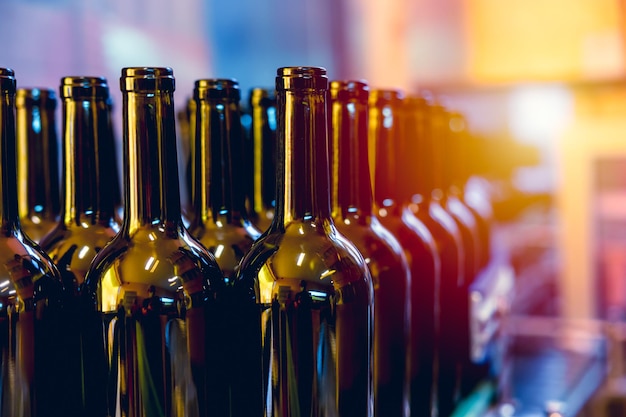 Garrafa de vinho na linha de produção da fábrica de bebidas da cervejaria para produtos de bebidas na correia transportadora