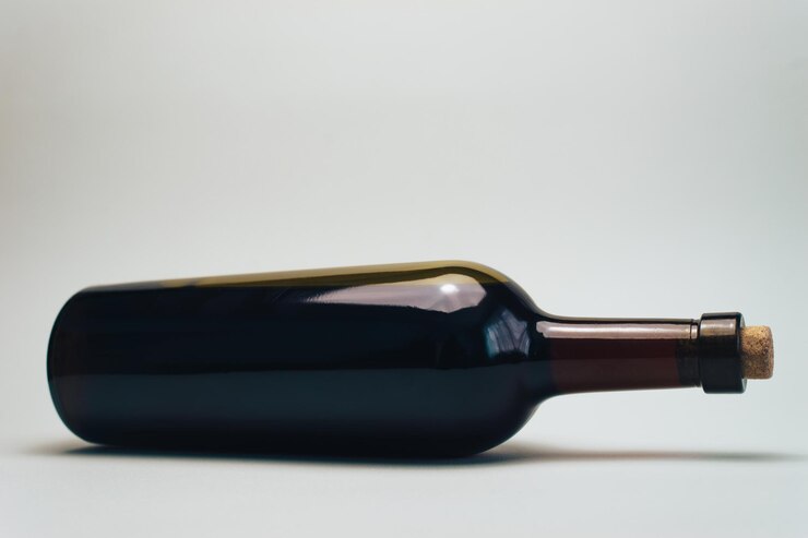 Foto garrafa de vinho vermelho em uma velha mesa de madeira de carvalho e fundo cinza
