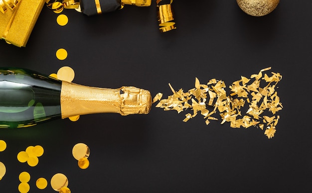 Garrafa dourada de champanhe derrama brilhos de ouro em uma moldura de ouro decoração festiva de Natal.
