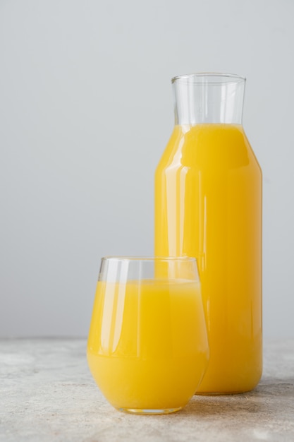 Garrafa e copo de suco de laranja de laranjas frescas