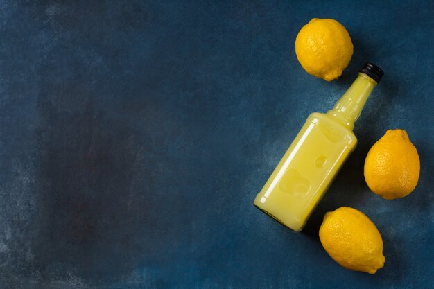 Garrafa Limoncello com limões em fundo azul