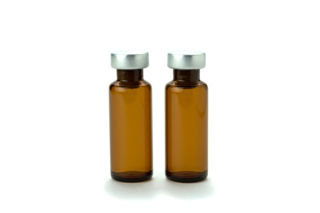 Foto garrafa médica de cor marrom para remédio e injeção com tampa isolada em fundo branco